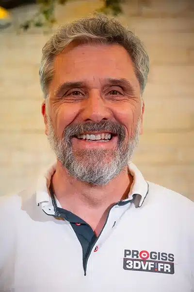 Homme souriant avec barbe grise.